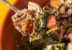 A spoonful of Italian wedding soup featuring meat greens and small pasta in a broth