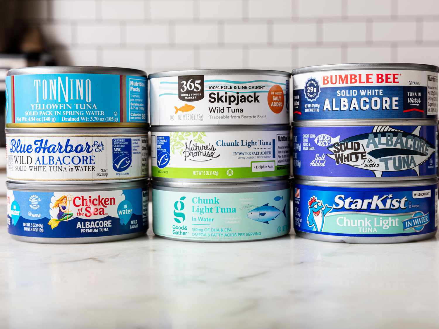 Stacked cans of different types of tuna in water 