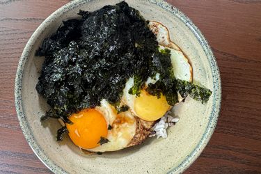 A bowl of gyeranbap a Korean dish with rice fried eggs and seaweed