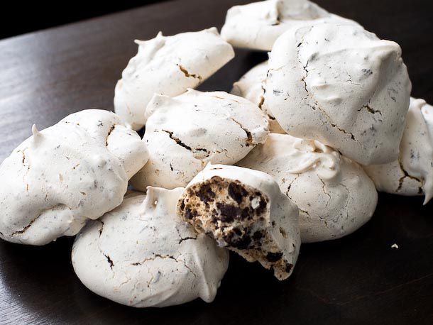Pile of chocolate chip meringue cookies with cross-section view of cookie's interior.