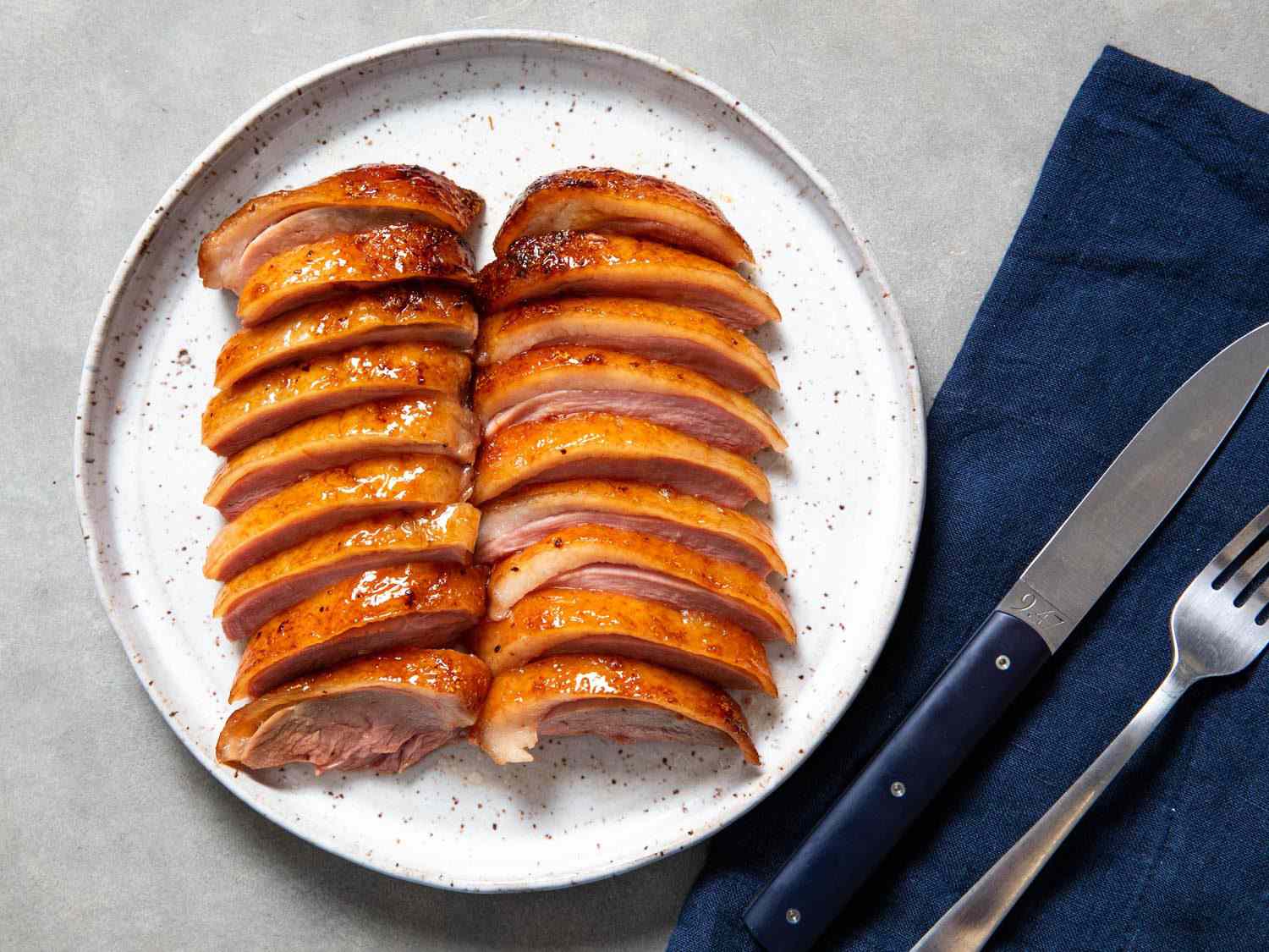 Overhead of sliced soy-maltose roast duck breast on a serving platter.