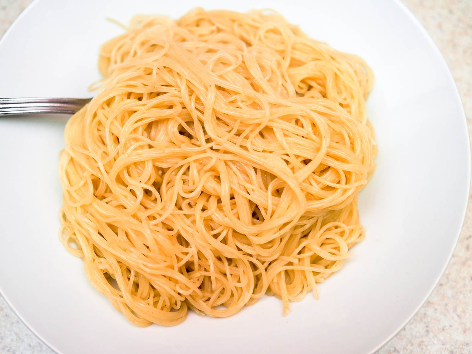 A plate with a pile of angel hair pasta cooked with baking soda. 
