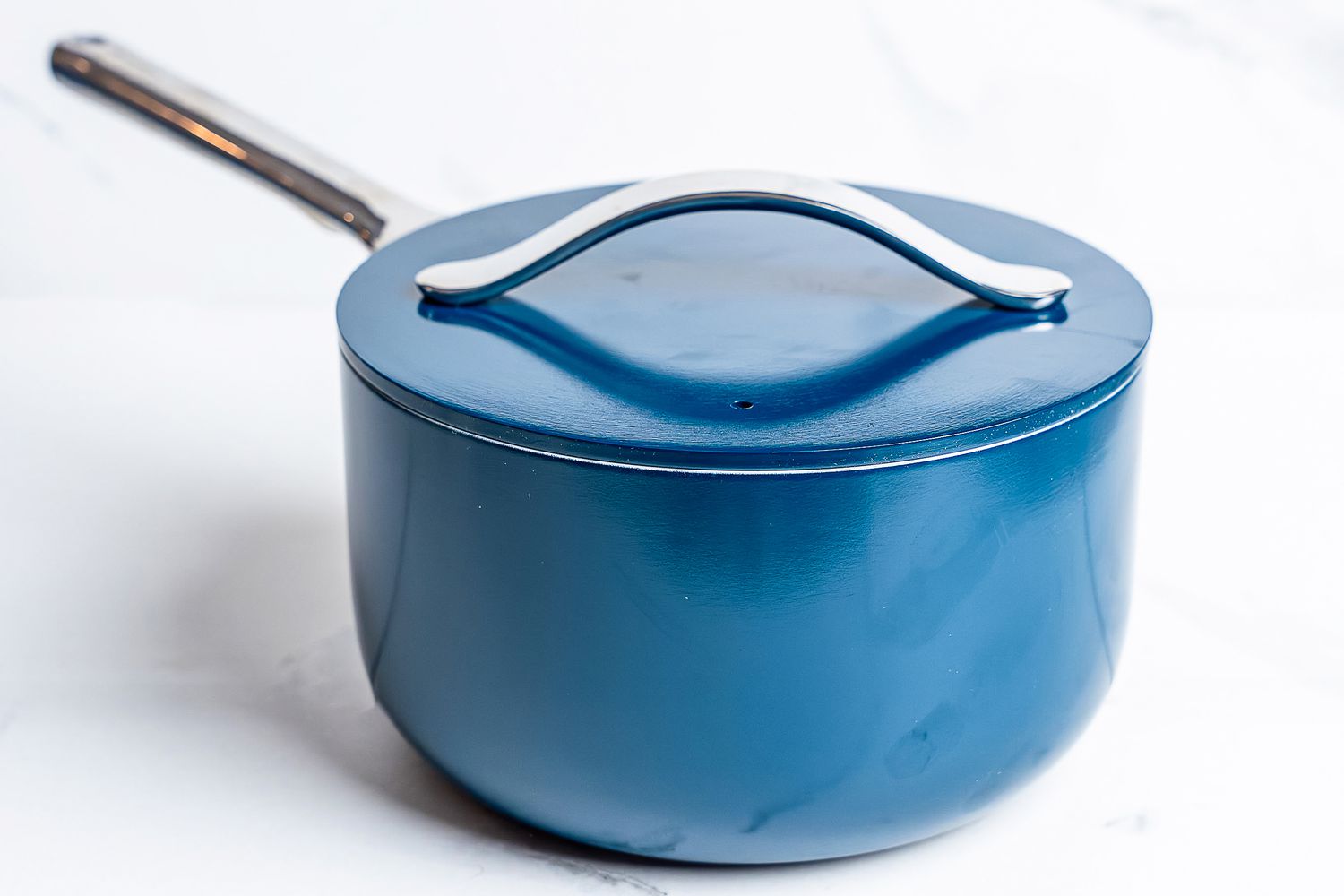 A pot from the Caraway Cookware Set on a white surface