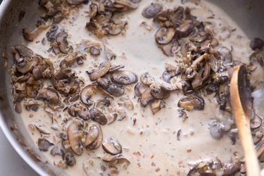 A creamy mushroom pan sauce is stirred in a skillet.