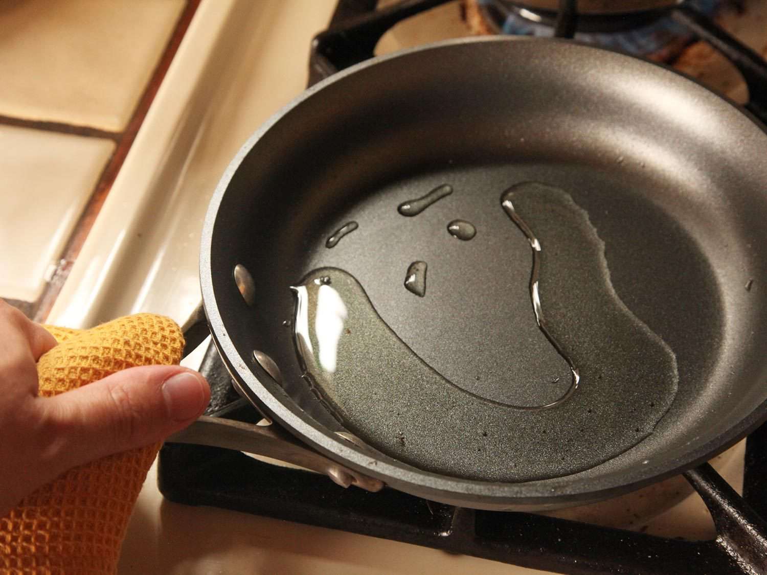Adding oil to nonstick pan.