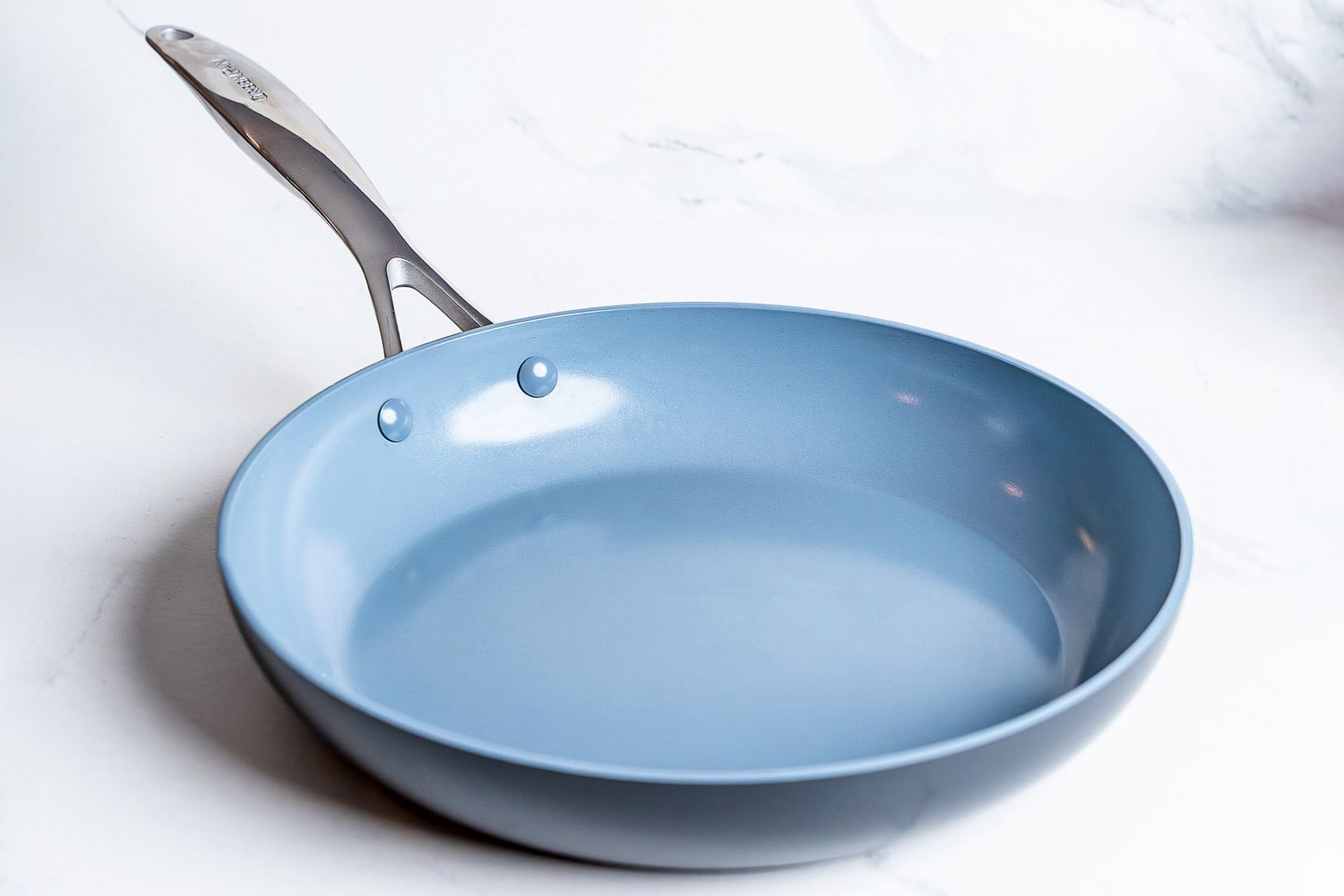 A pan from the GreenPan Valencia Pro Ceramic Nonstick 11-Piece Cookware Set on a white surface