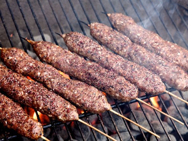 Close-up of Adana kebabs on the grill.