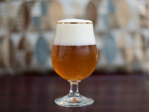 A glass of Belgian Tripel beer with a good head of foam 