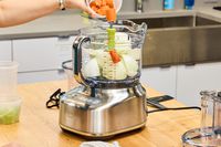 A person puts vegetables into the Breville BFP838BSS1BNA1 16-Cup Paradice Food Processor
