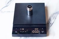 Hario Polaris Coffee Scale with a 100g calibration weight on it