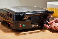 Person turning knob on Krups 4-Slice Belgian Waffle Maker