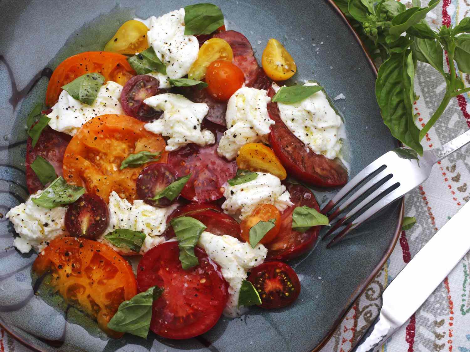 Caprese salad made with assorted colors and sizes of tomatoes