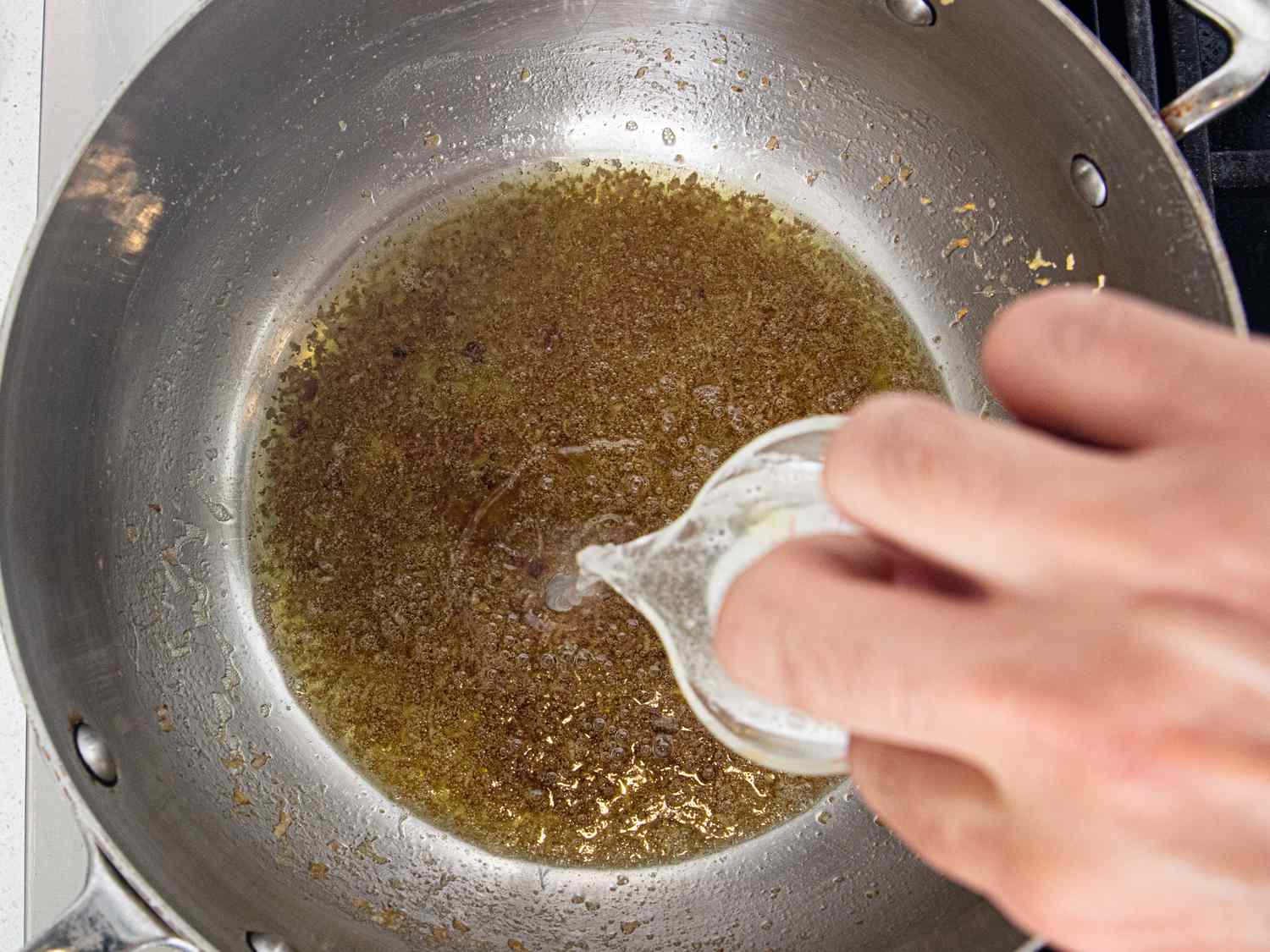 Overhead view of adding pasta water