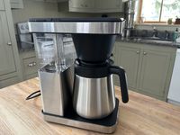 The OXO Brew 8-Cup Coffee Maker on a wooden table in a kitchen