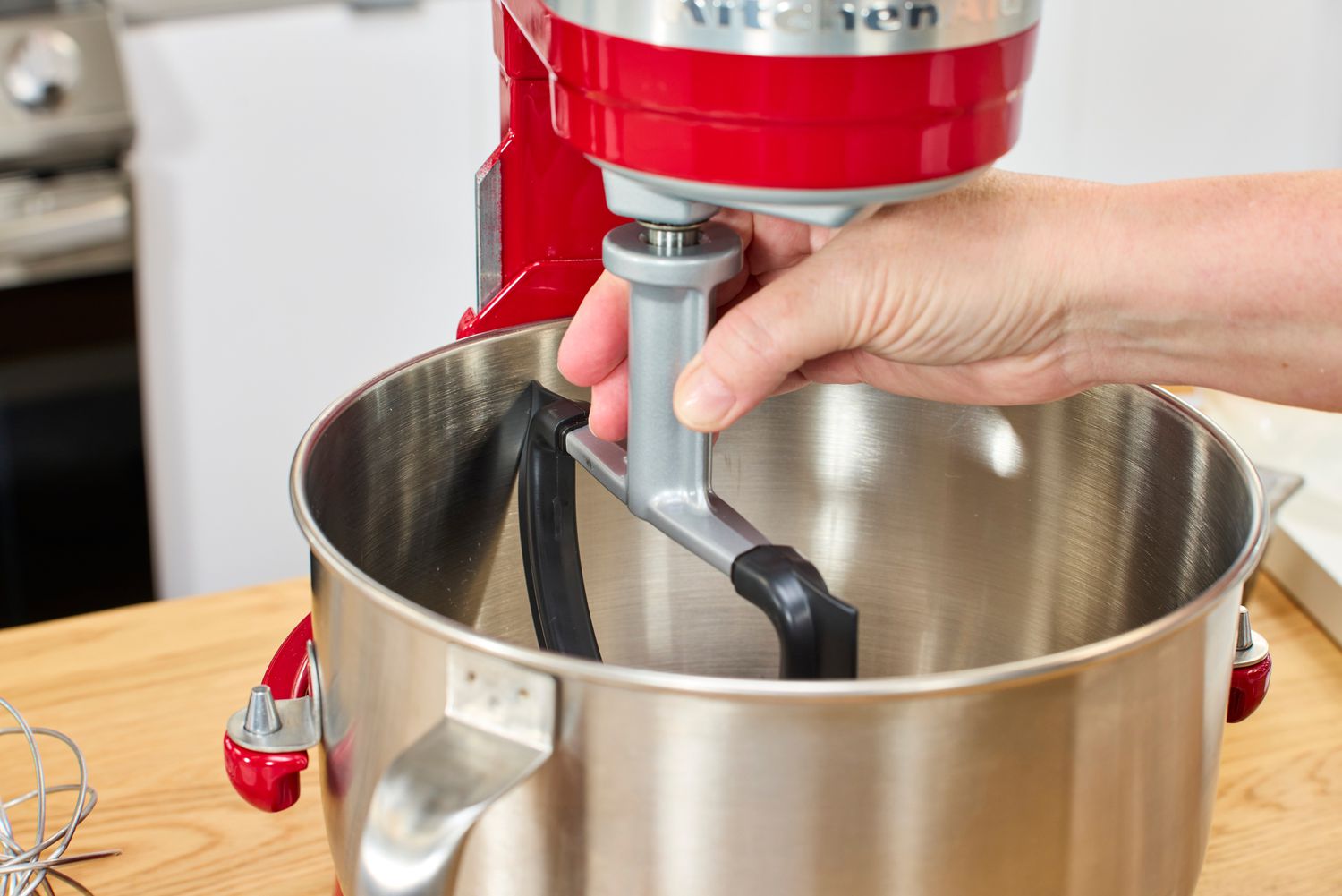 A person attaching a stand mixer's paddle to the stand mixer.