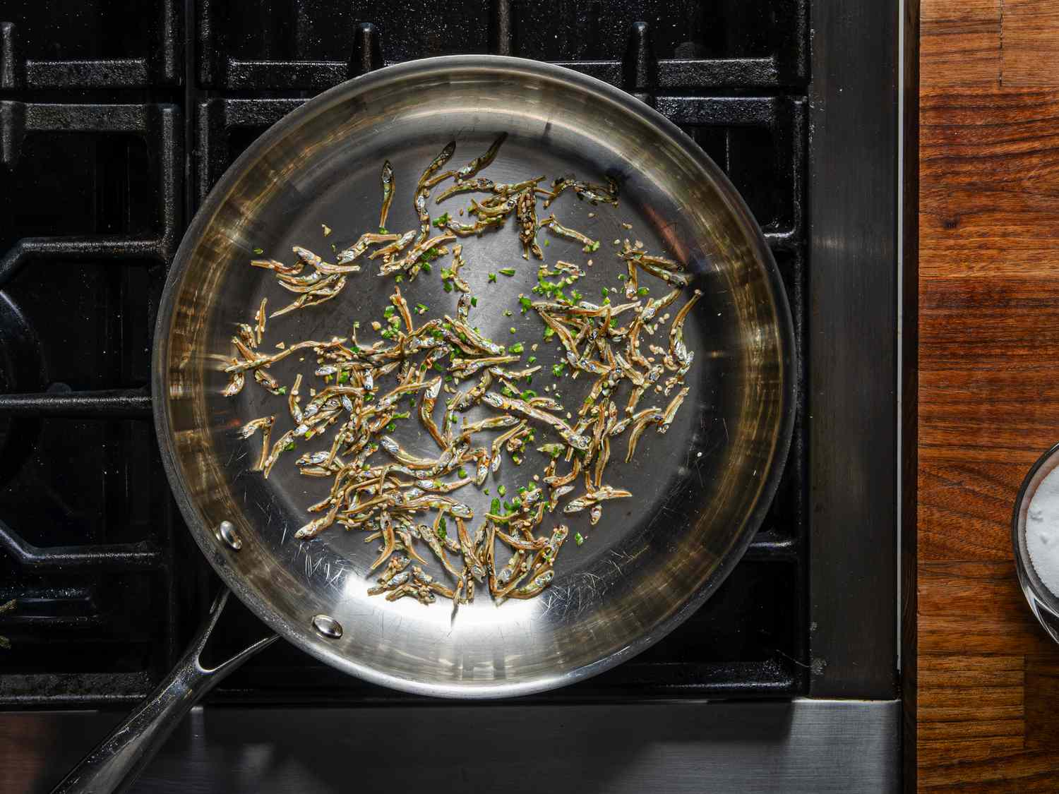 Overhead view of anchovies and chiles in a skillet
