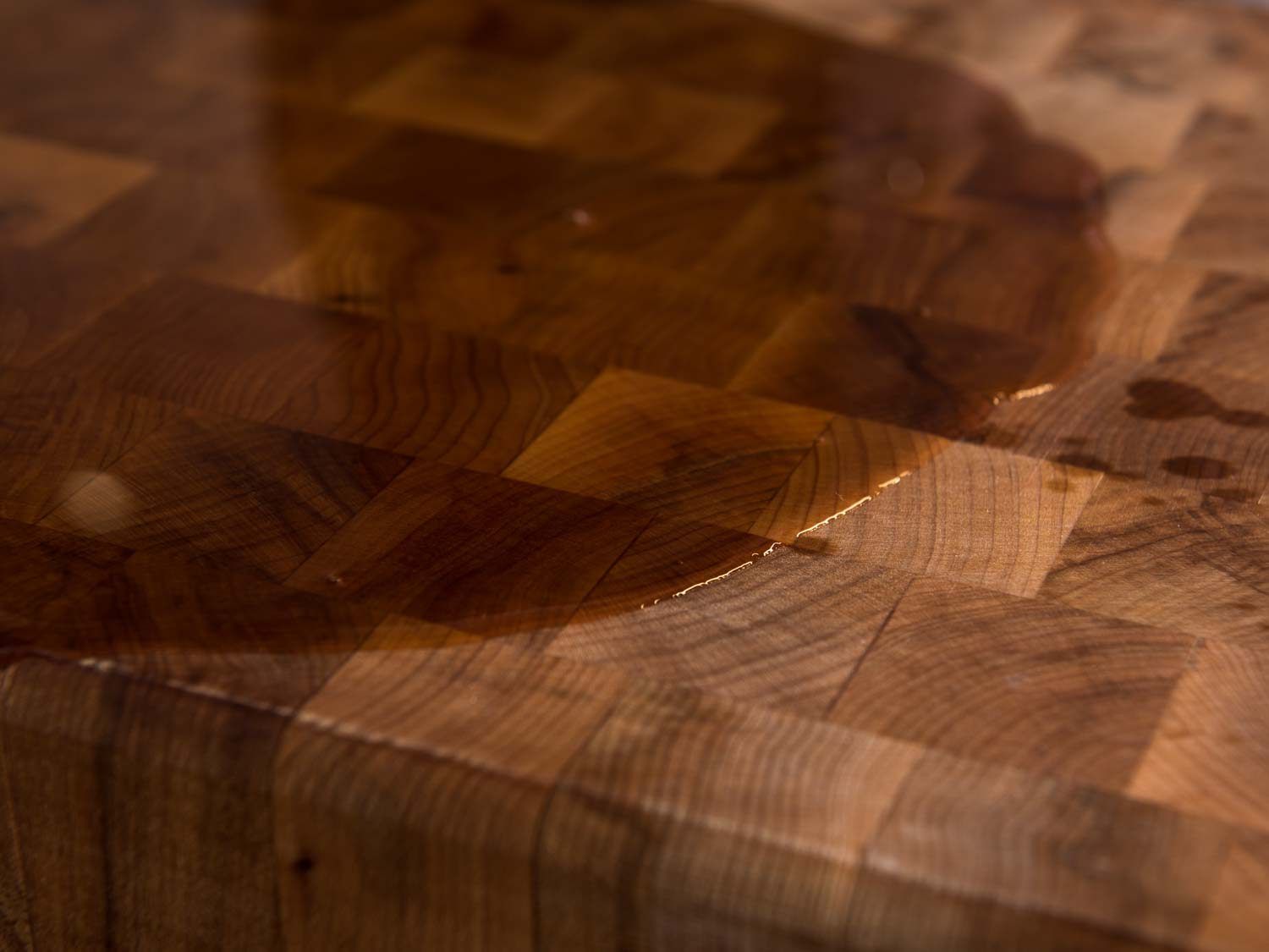 Closeup of mineral oil soaking into a wood board.