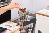 A person pours coffee beans into the Baratza Sette 270 Conical Burr Grinder
