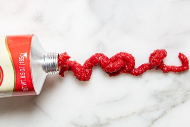 A tube with a red substance squeezed onto a surface