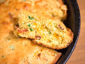 Cross-section view of cheddar, bacon, and scallion cornbread in cast-iron skillet