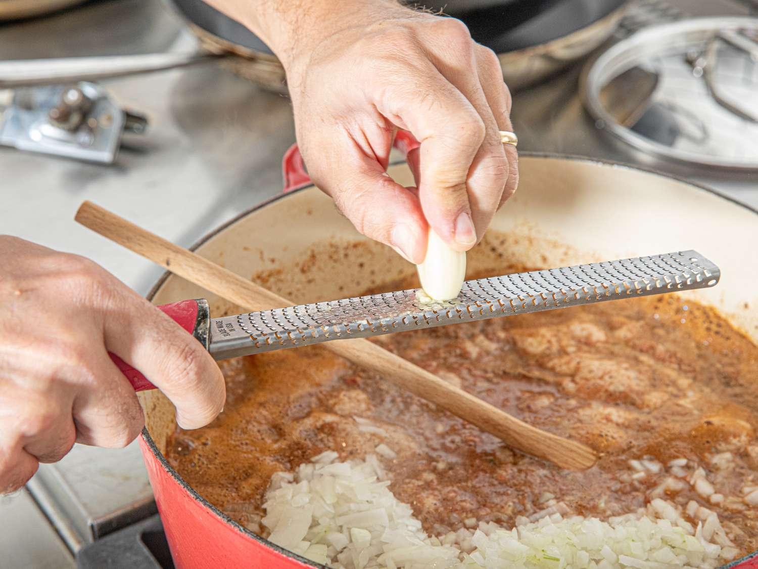 Side view of grating garlic into chili