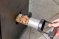 Hand placing the wood tray in the Masterbuilt MB20072918 40-Inch Digital Electric Smoker