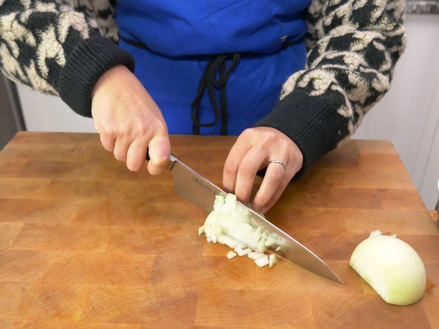 a person using the misono ux10 to dice an onion
