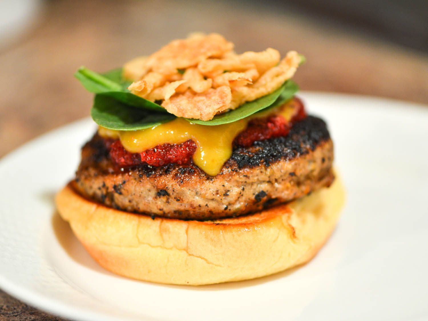 Turkey burger topped with cranberry relish, gravy, spinach leaves, and fried onions