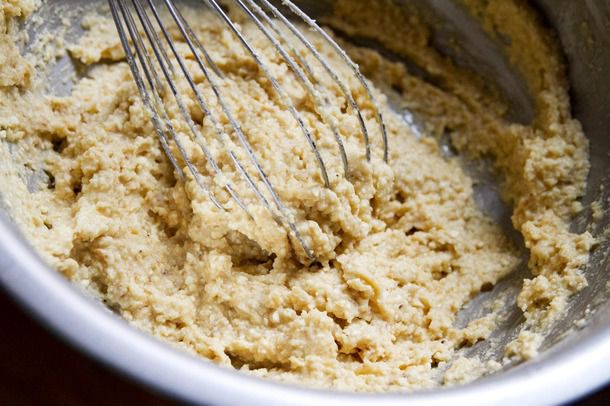 A whisk combining matzo ball mix in a metal bowl