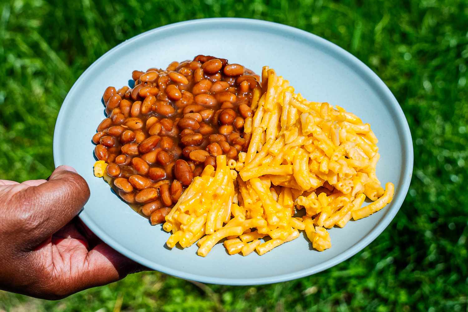Year & Day The Outdoor Core Set plate of beans and macaroni being held outdoors