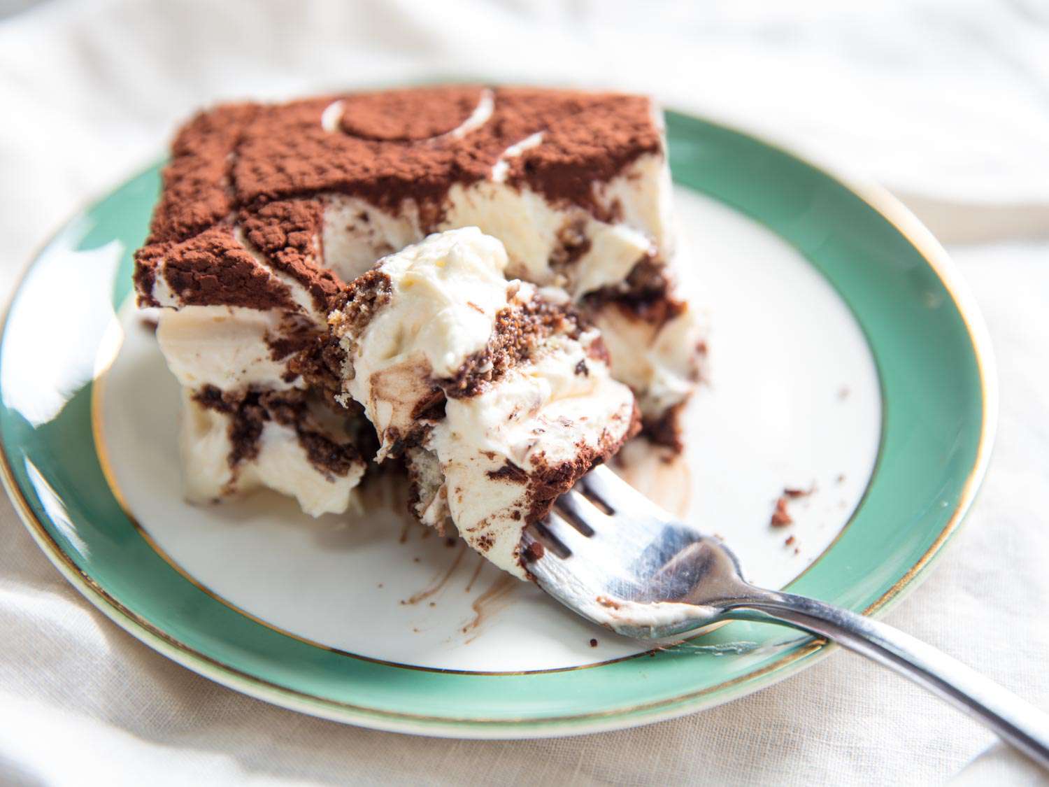 A slice of tiramisu with a bite taken out of it.