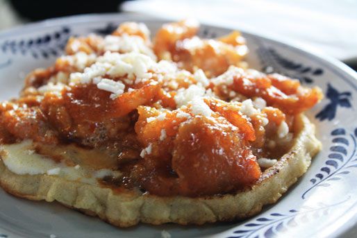 Close up view of chicharrones guisados on a sopes. 