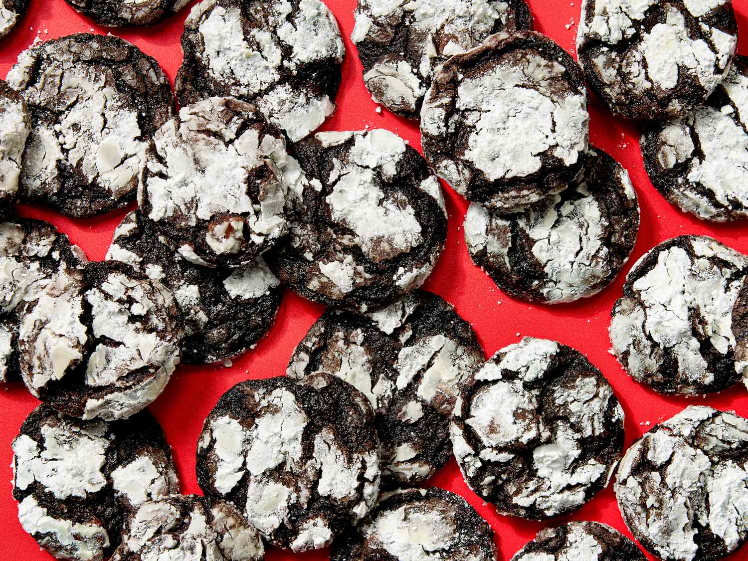 Chocolate crinkle cookies arranged on a red surface