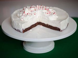 A frozen black bottom peppermint pie, served on a cake stand. Several slices have been consumed.