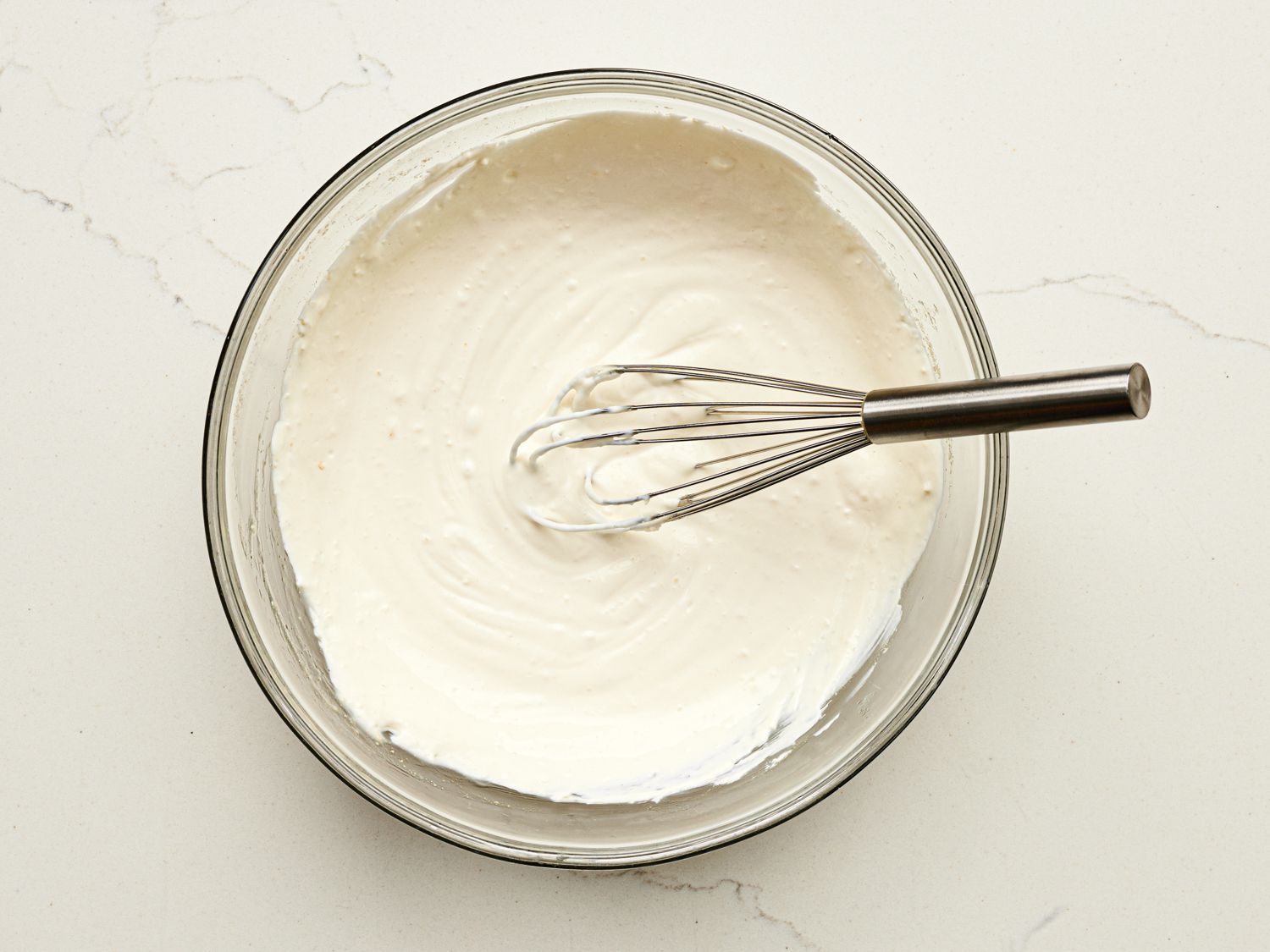 Overhead view of whisking ingredients together in a bowl