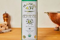 A bottle of Frankies Organic Extra Virgin Olive Oil on a kitchen counter