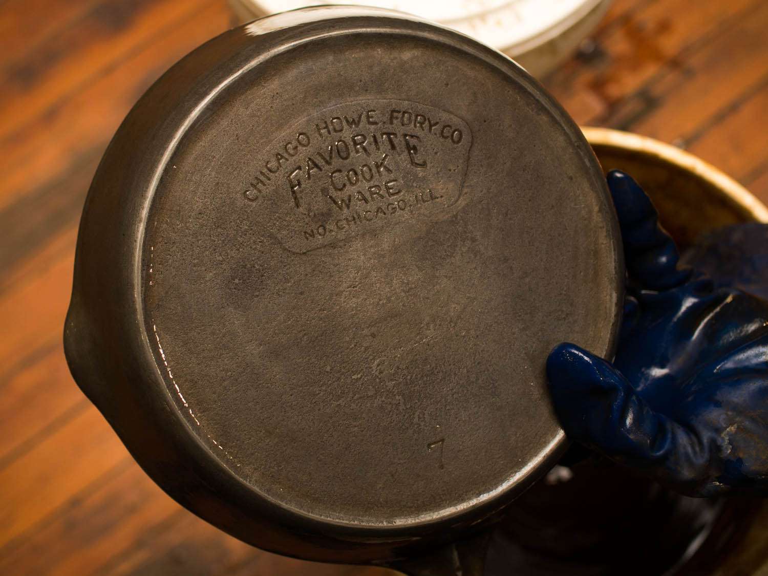 A restored vintage piece of cast iron cookware. The words on the bottom of the skillet read: Chicago Howe Fory Co - Favorite Cook Ware.