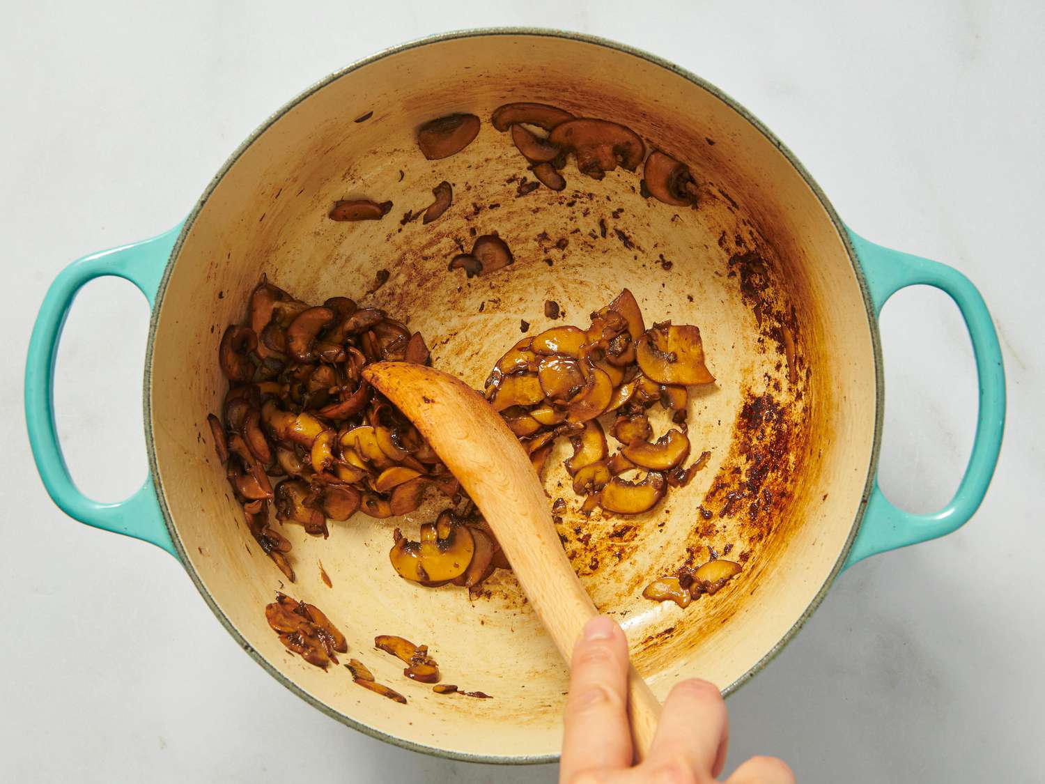 stirring sauted mushrooms in dutch oven 