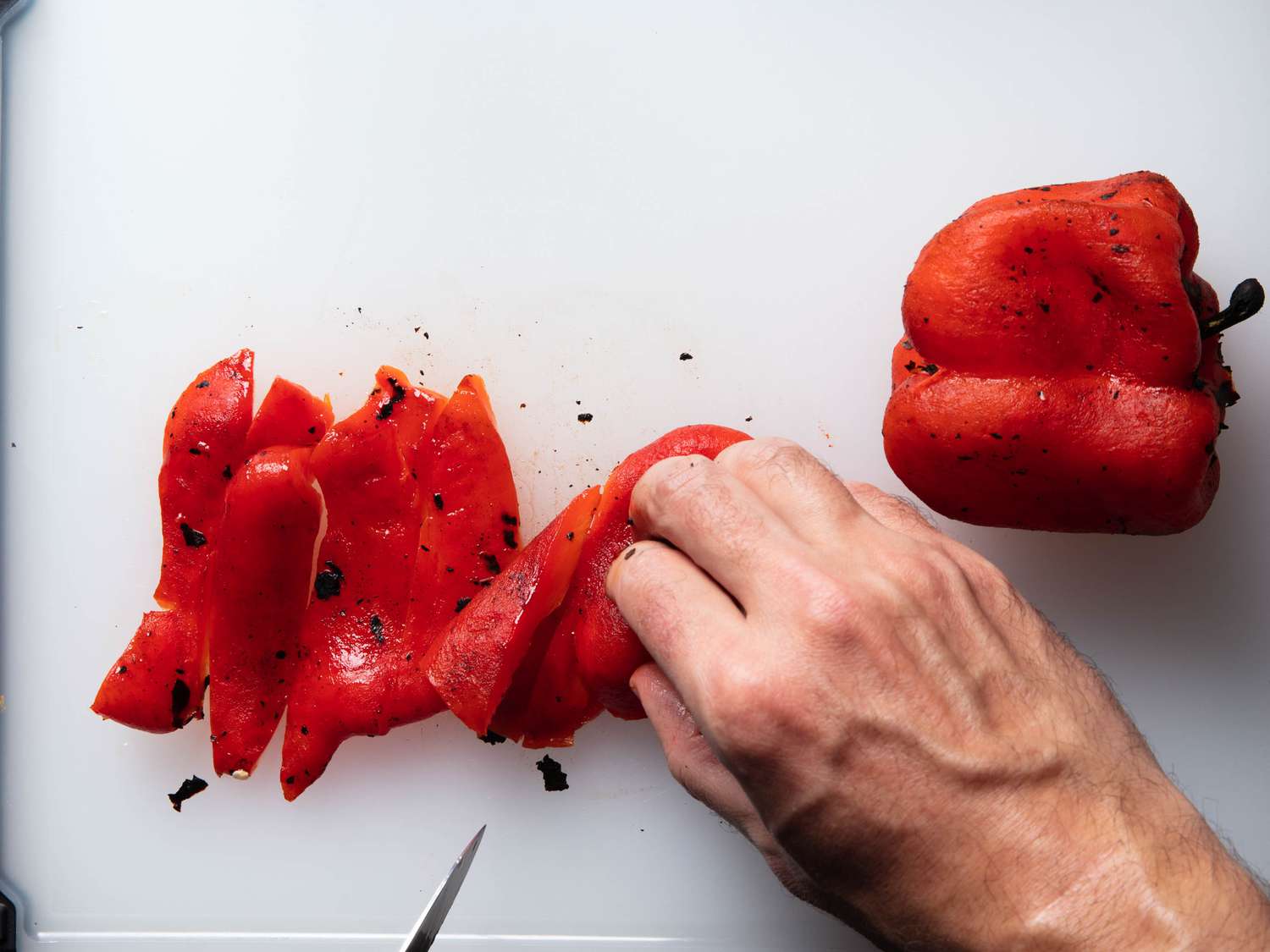 Chopping the roasted pepper flesh after the charred skins have been cleaned off.