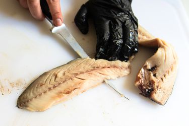 A person using the Wüsthof Classic Fish Fillet Knife to cut a fish