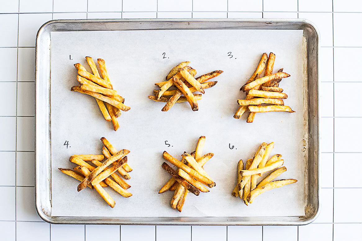 Six sets of cooked French fries arranged on a baking sheet with numbered labels from 1 to 6