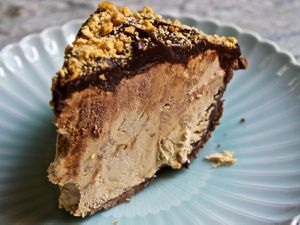 A slice of Snickers pie on a blue plate.