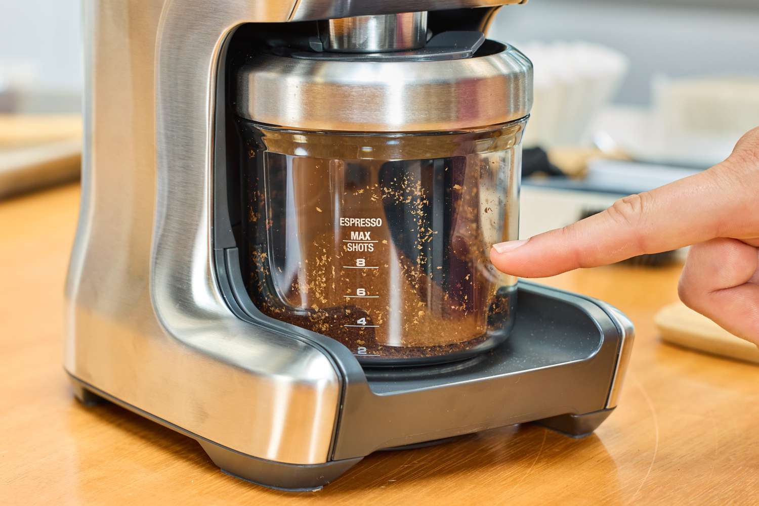 A person points to the measurements on the Breville The Smart Grinder Pro