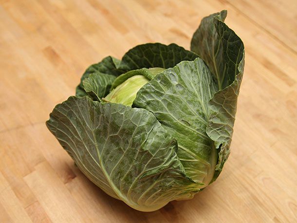 A head of green cabbage on a wood surface