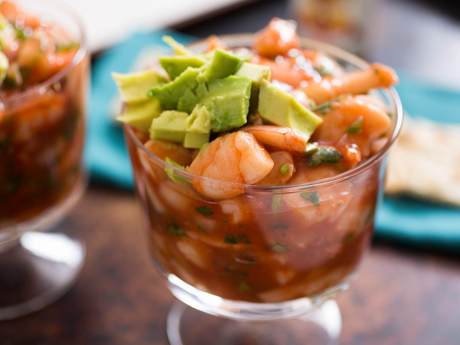Side view of Mexican shrimp cocktail and diced avocado in a short parfait glass.