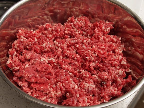A mixing bowl half-full of ground meat.