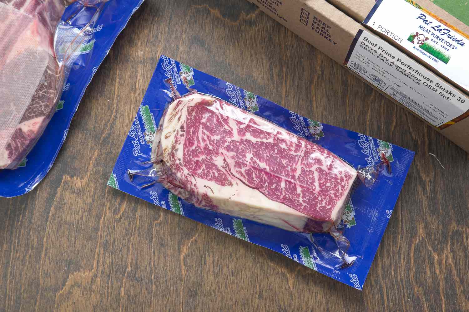 A packaged portion of marbled steak on a wooden surface