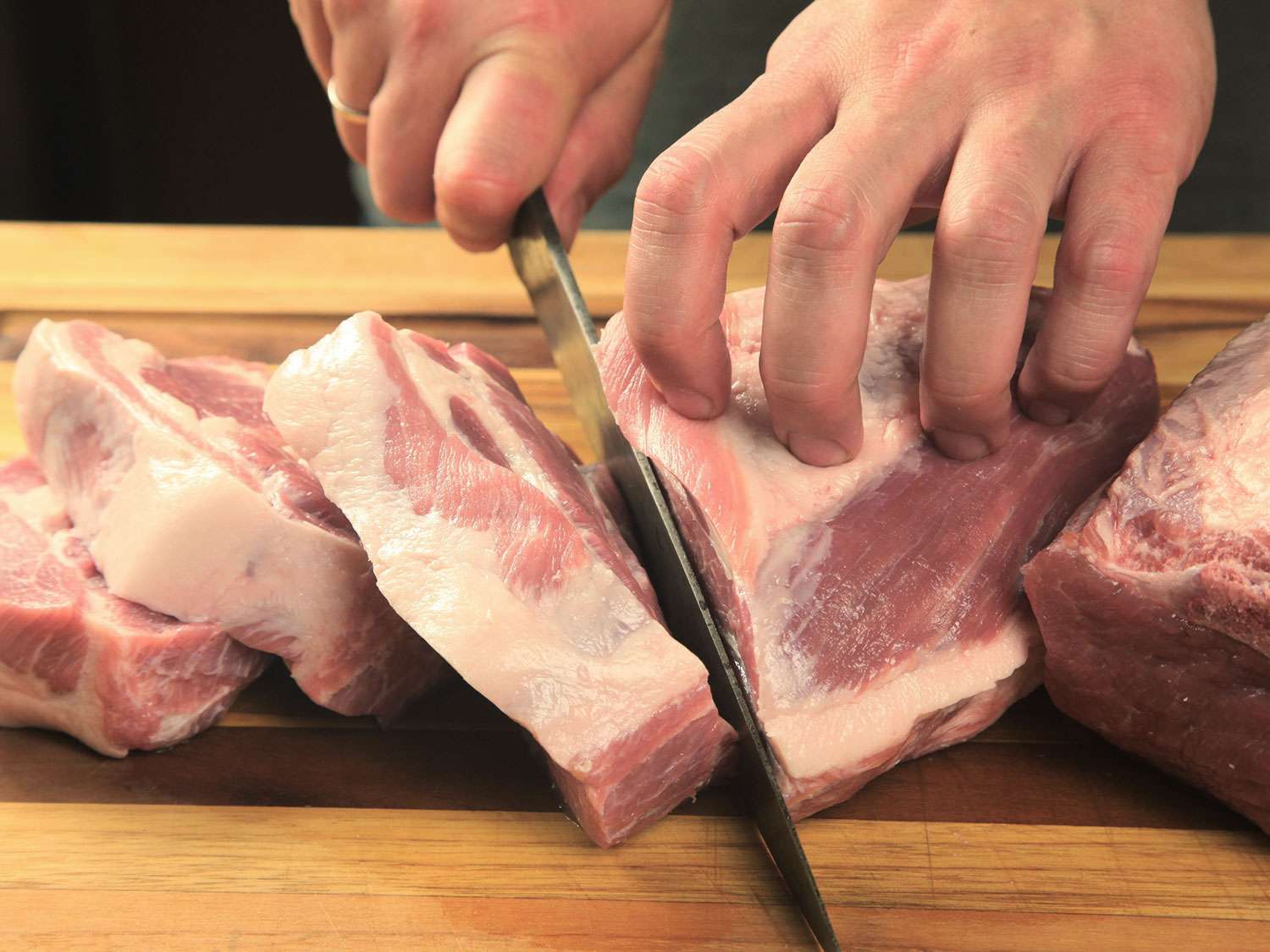 Slicing pork shoulder into slabs for sous vide carnitas.