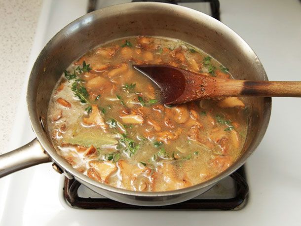 The saucepan with the strained stock added, as well as a bay leaves and thyme sprigs, ready to simmer.