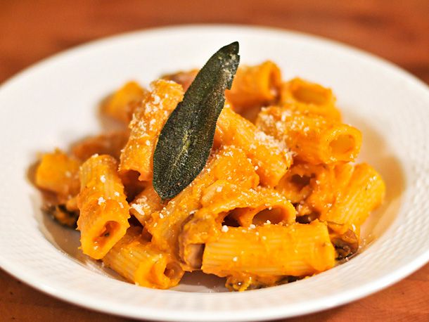 A plate of pasta coated in butternut squash and sage cream sauce. 